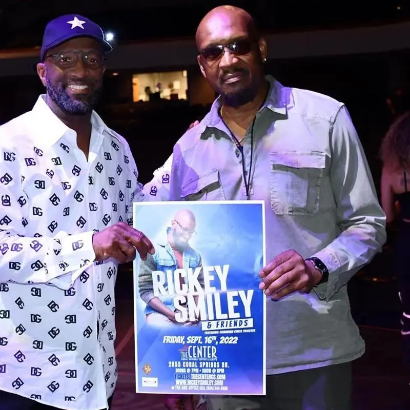Two men holding a poster of the show.