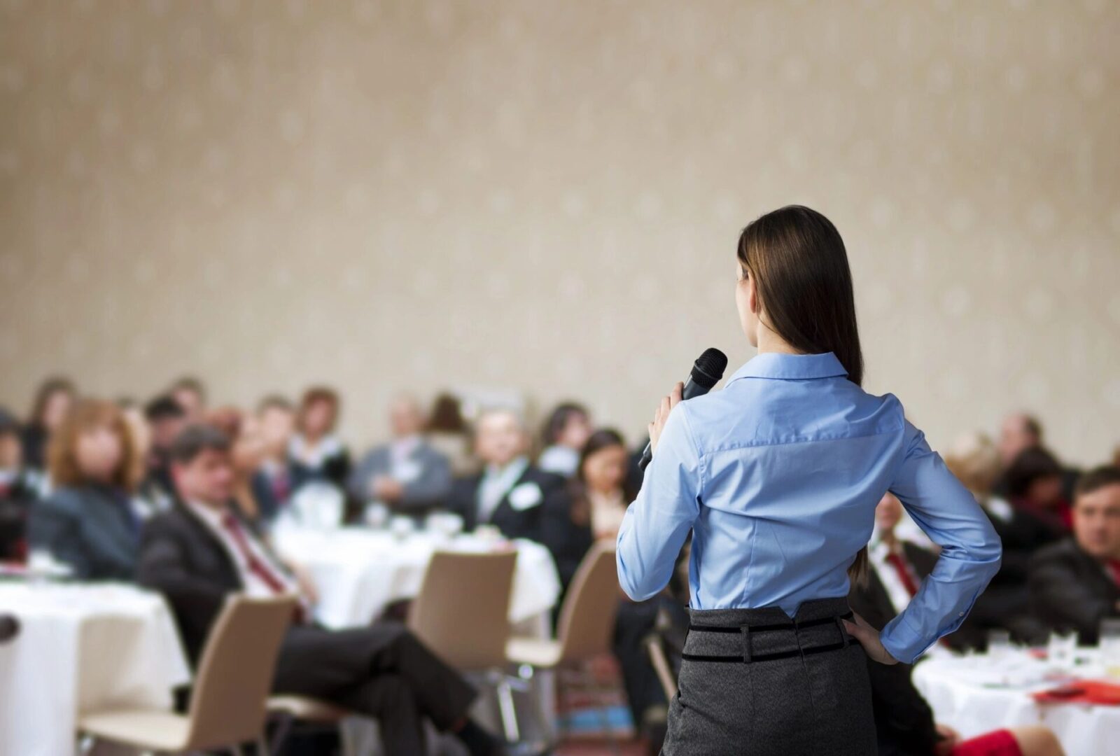 A woman is speaking to an audience at a conference.